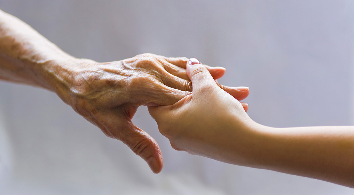 A young hand reaching out to an old hand